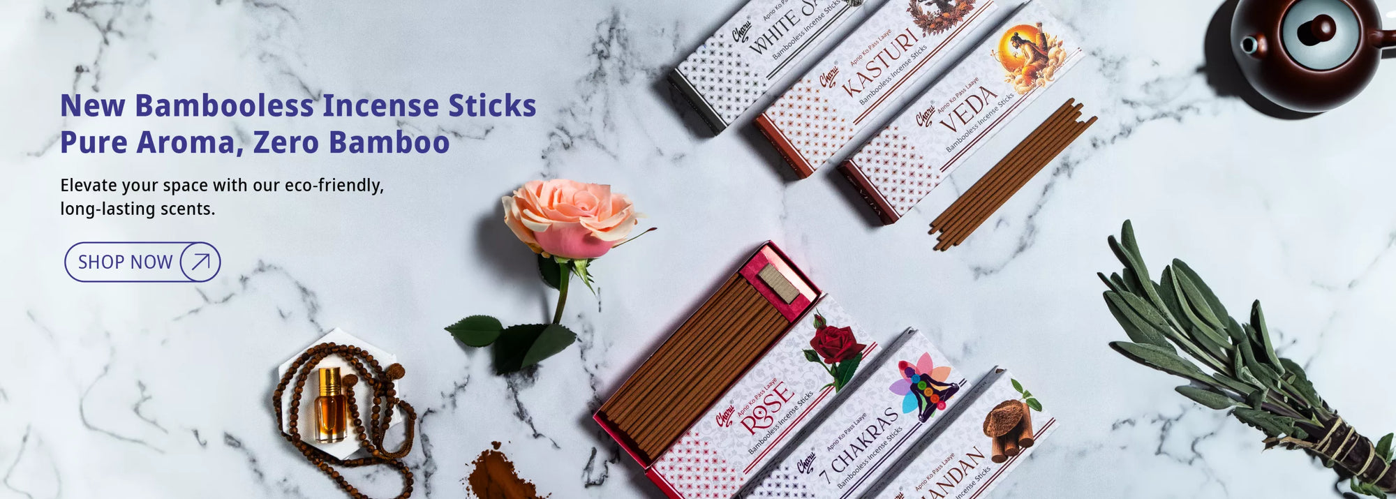 Charu Bamboooless Incense Sticks in assorted fragrances with rose, sage bundle, diffuser, and perfume bottle on a marble background.